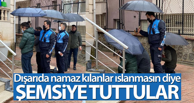 Zabıtalar dışarıda namaz kılanlar ıslanmasın diye şemsiye tuttu